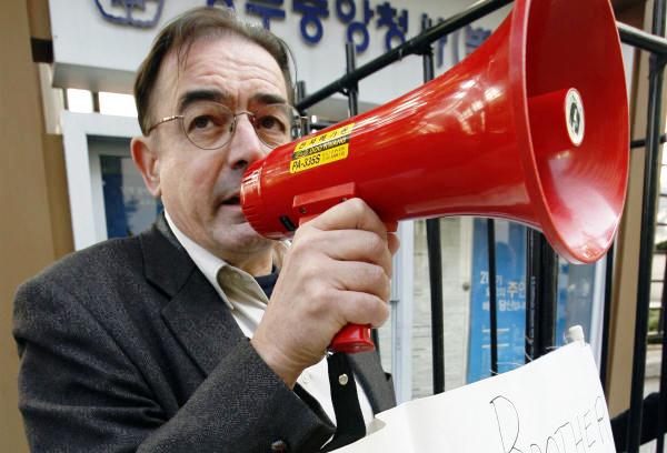 Rev. Tim Peters speaks through a megaphone at a protest in Seoul